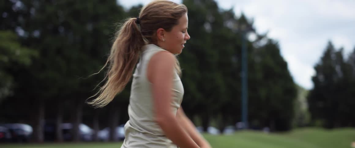 A young woman swing her golf club and then looks frustrated