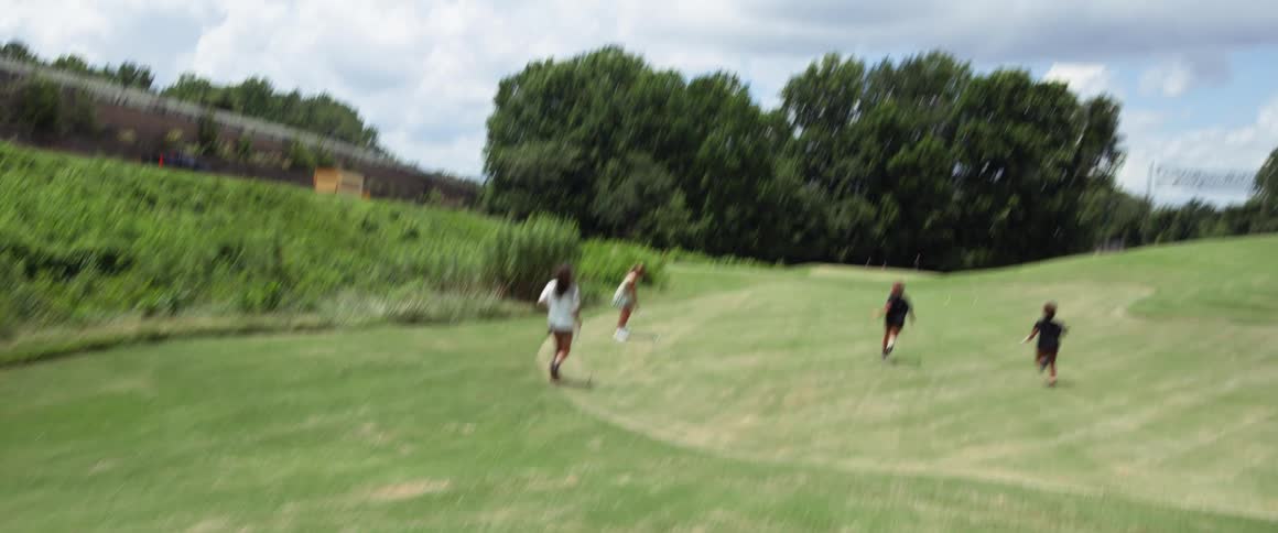 The children run together on the golf course