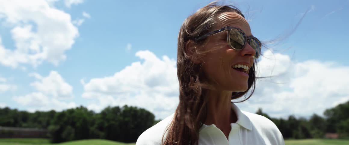 Woman with sunglasses in a field outdoors