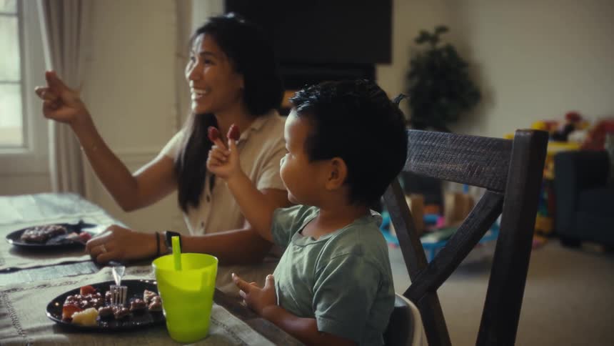 Happy family gathered around a dinner table during the day