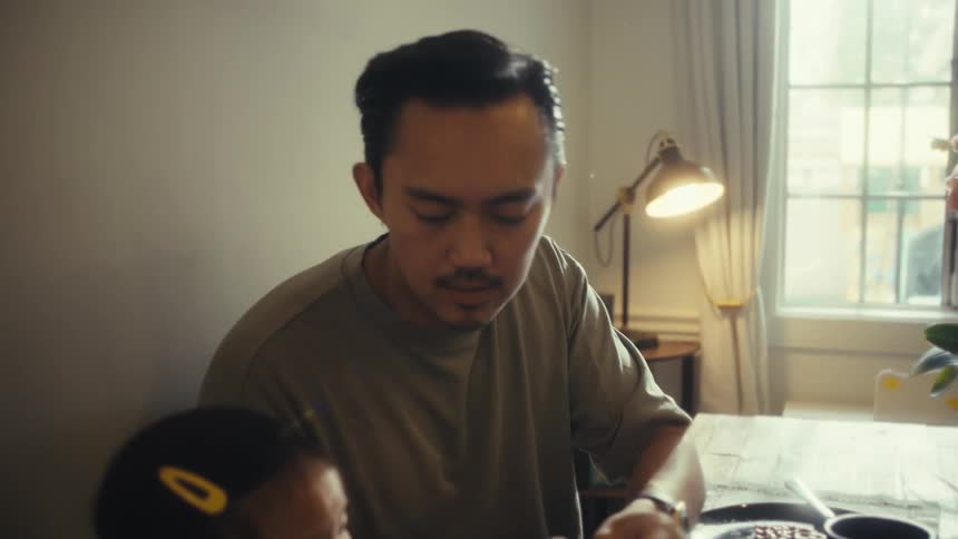 Father and mother sitting at the table with their two young children