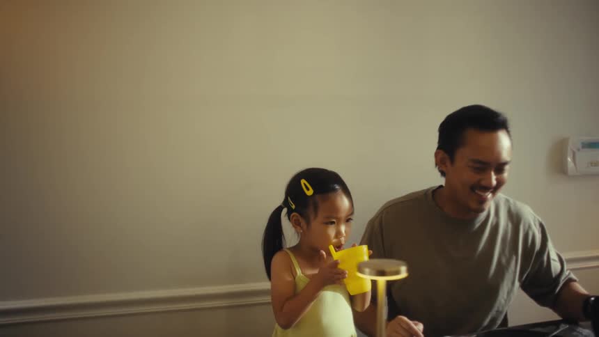 Father and mother with their two young children having lunch at a table