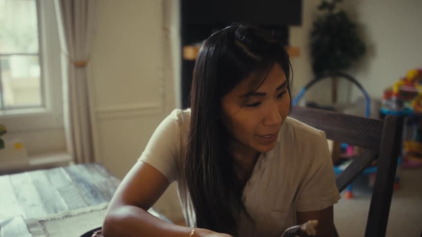 Mother feeding her little son sitting at the table