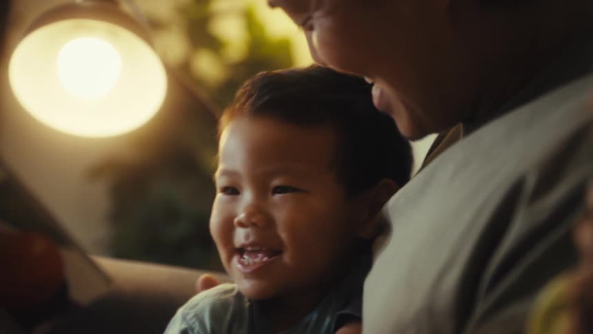 Father and son laugh while reading a book