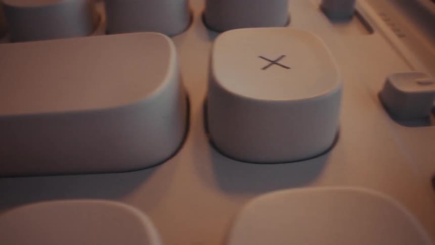 The video shows a persons hand pressing a large lightcolored plus button on a calculator the camera then pans across other buttons on the calculator revealing the multiplication sign x and the percentage symbol the calculator has a mod