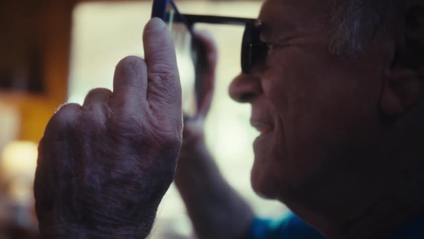 A person with a hand holds a device with a lens to their face and looks through it with an open mouth
