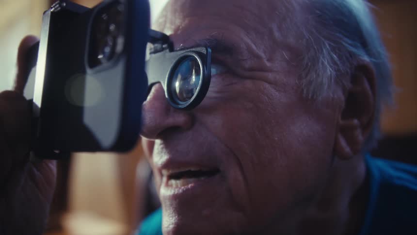 A person with a viewer on their face and hands on the smartphone looks forward with an open mouth