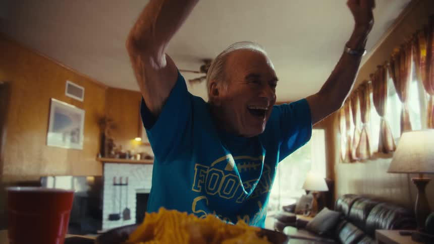 The man raises his arms and cheers