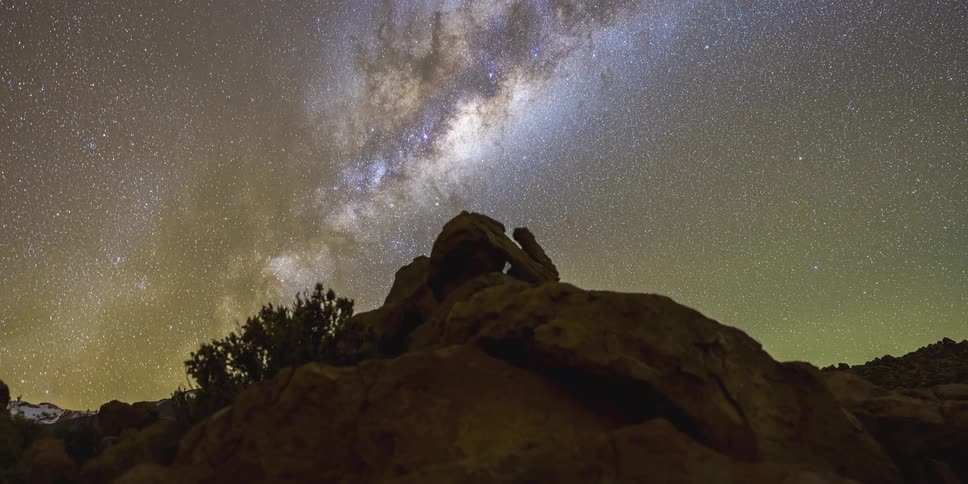 A time lapse of the starry sky over a rocky landscape