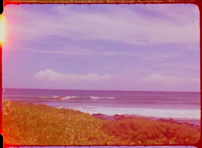 Person surfing on the sea next to the coast outdoors during day time