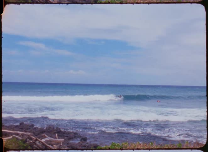People surfing a wave on the horizon of the sea
