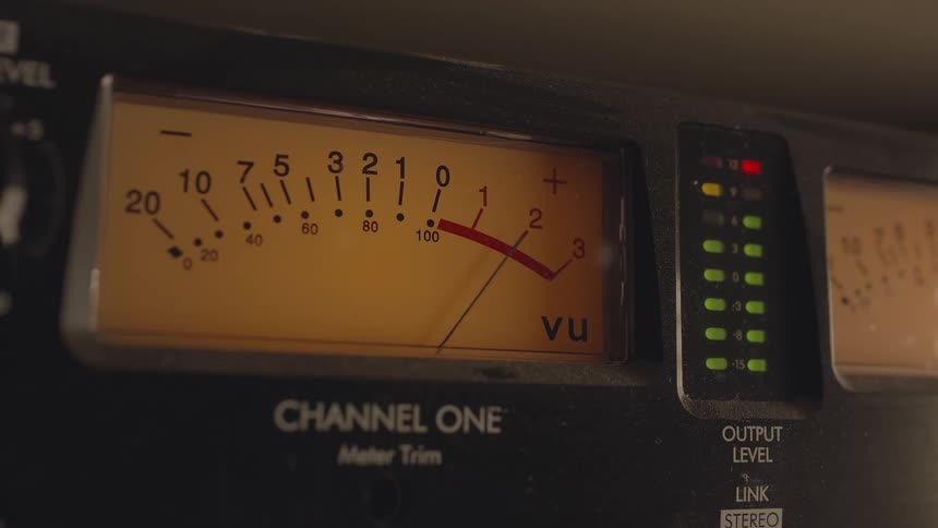 A device with a dial and a needle moves to indicate a channel being used