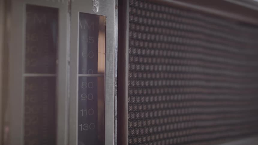 The frequency is gradually adjusted on an older model of radio
