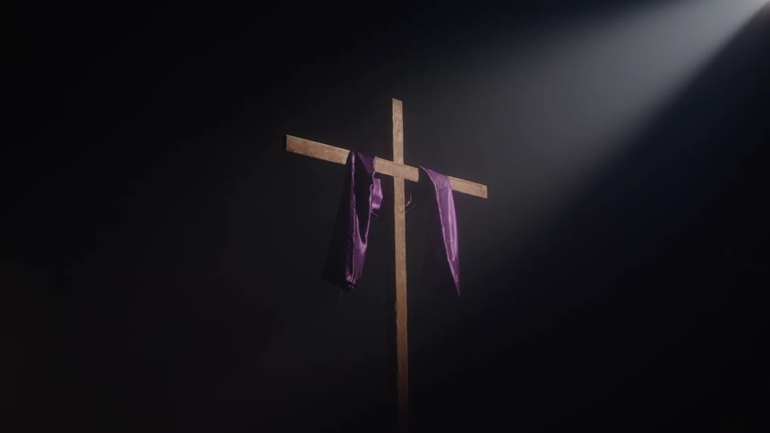 Purple scarf on a wooden cross in a dark room with natural light reflection