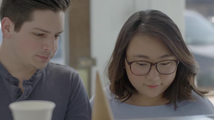 A man and woman are looking at selections in an ice-cream parlor