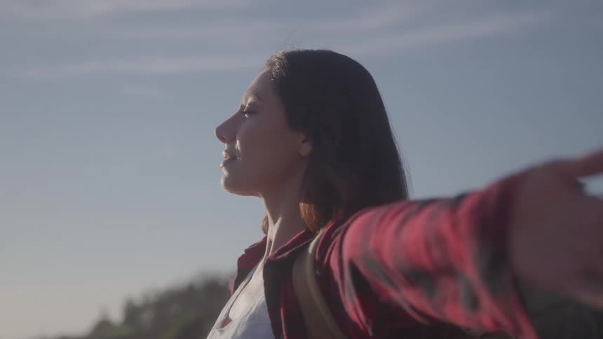 The woman is smiling with her arms up in the air