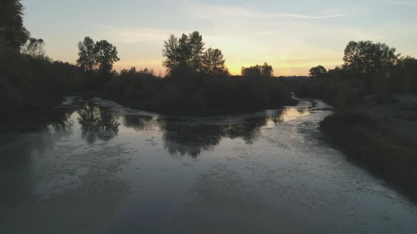 Late afternoon landscape of a winding river with sparse vegetation