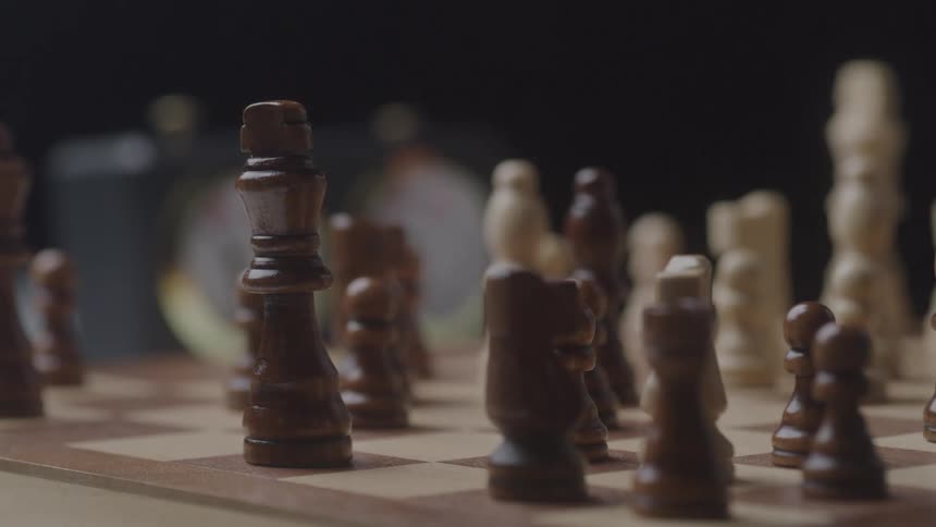 Two people playing chess with one of them knocking over all the pieces