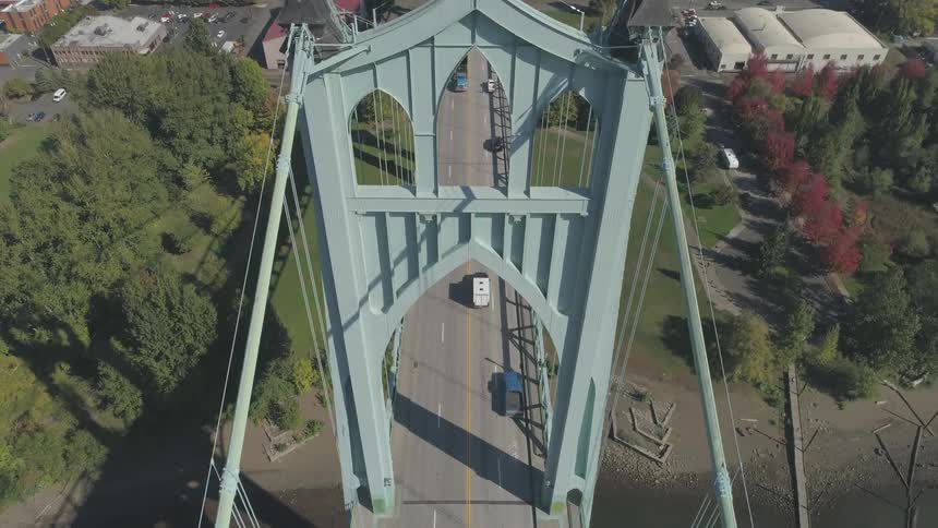 Light blue suspension bridge stretches over a road in the middle of the city