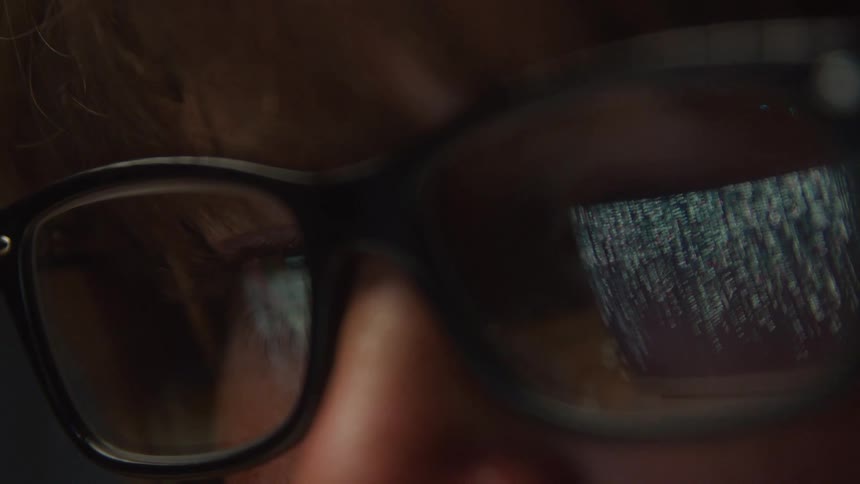 Closeup of a persons glasses displaying a screen