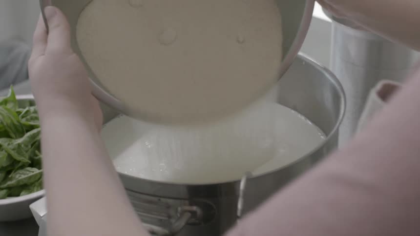 Woman pours granules into a large pot