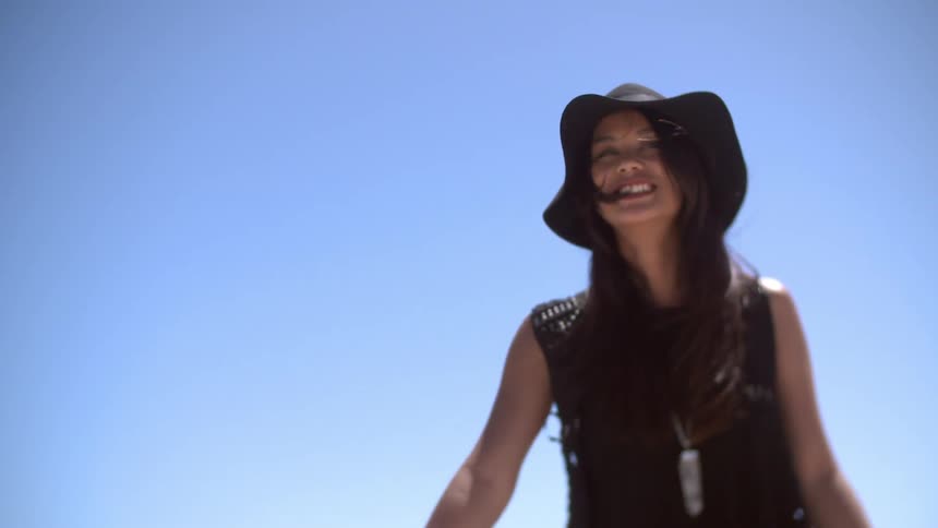 Woman in hat smiling outside
