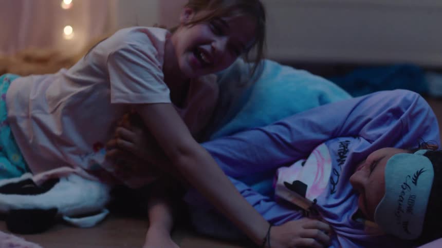 Two girls tickle each other on the floor