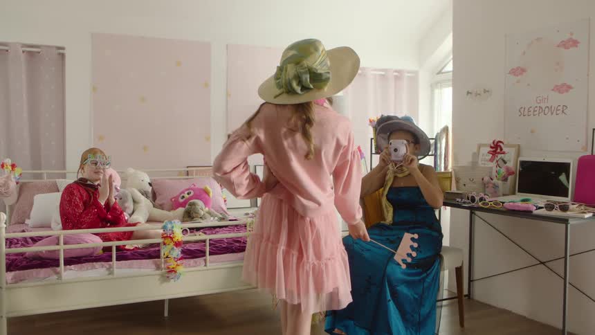 Three girls enjoy dress up playtime during a fun sleepover indoors