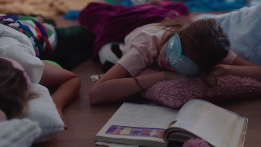 Children nap on the floor with pillows and blankets