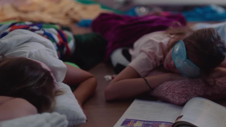Girls nap on the floor during a sleepover