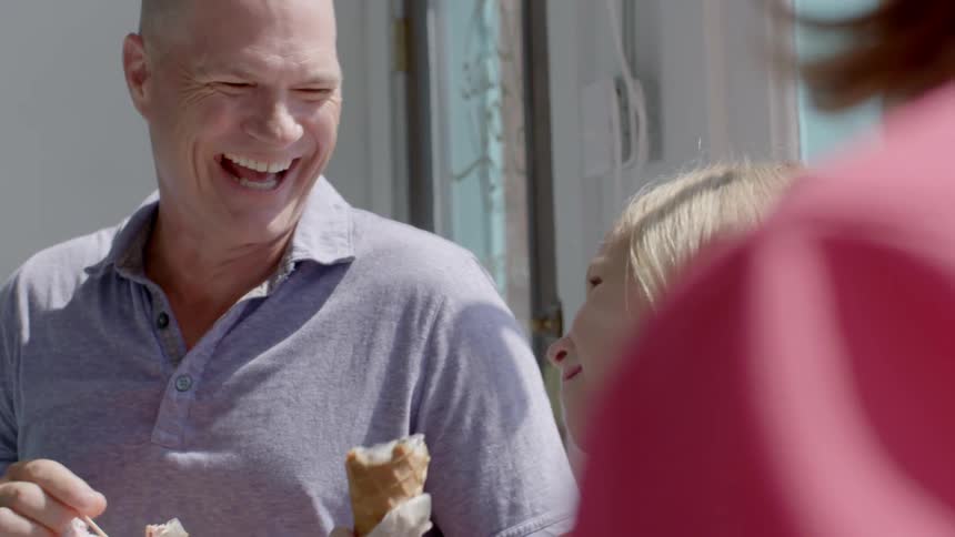 A family laughs and eats ice cream