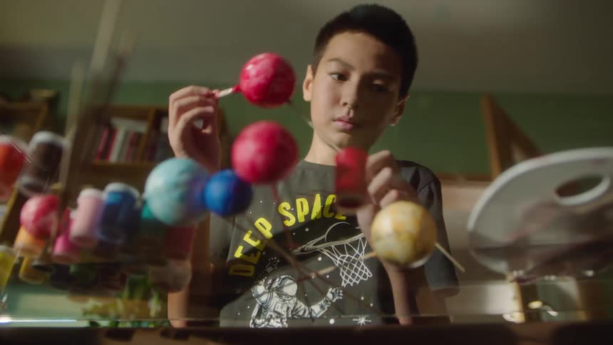 The boy is painting small orbs