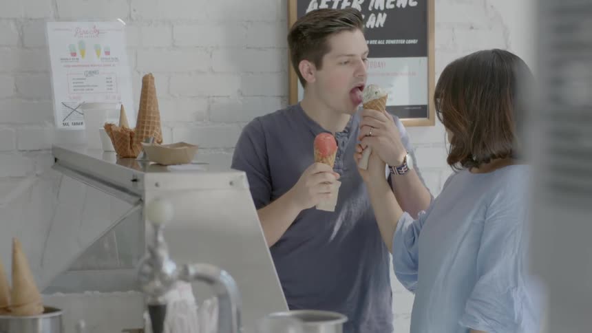 Two people eat ice cream in a shop