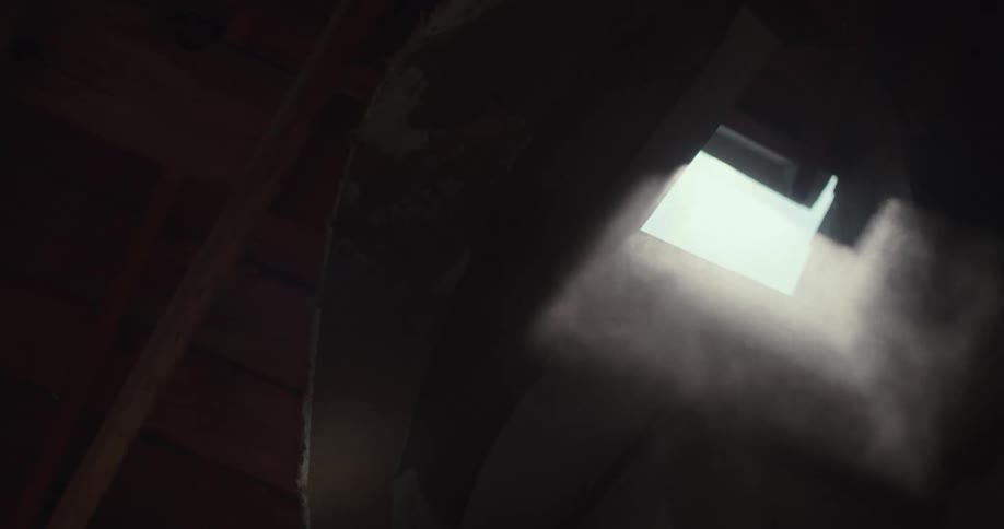 Dust floats up out of the window in the dark room