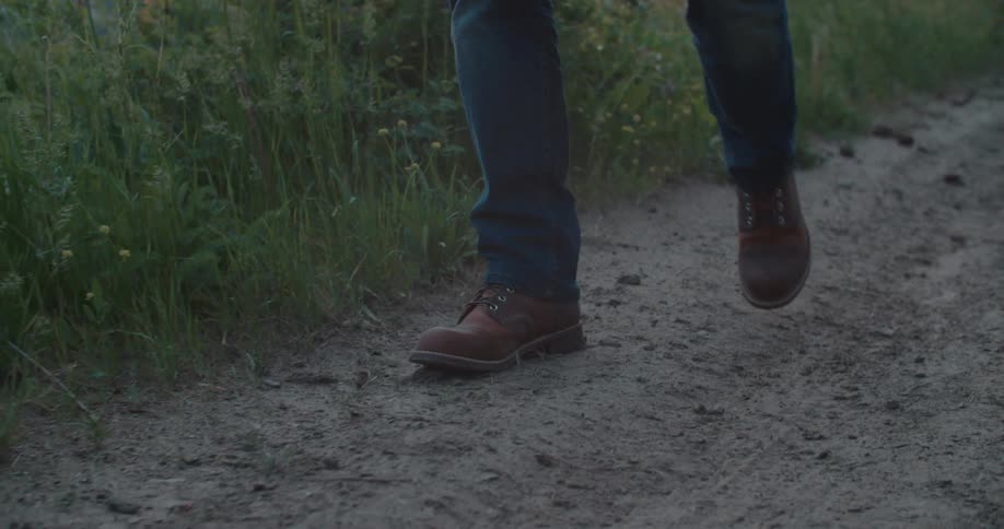 Person in shoes and jeans walking along a trail