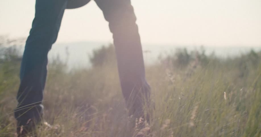The man walks through the green grass