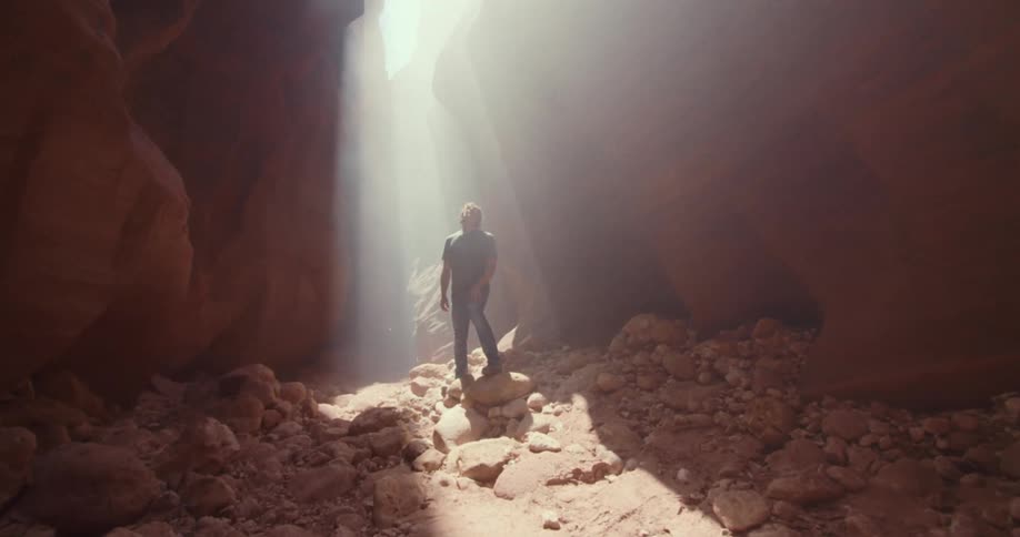 Man walking along a trail between rocks exploring