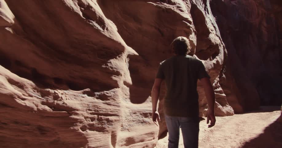 Man walking through ruins with natural erosion