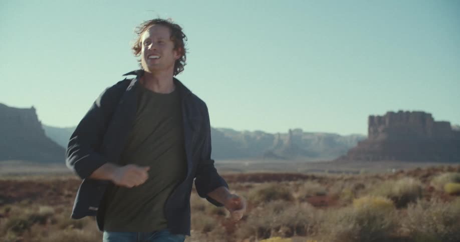 Man walking and running outdoors with canyons on the horizon