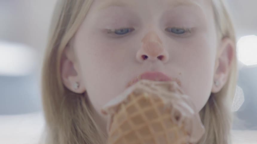 A girl licks an ice cream cone