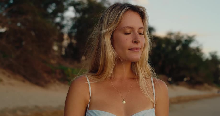 Blonde woman on the beach at sunrise