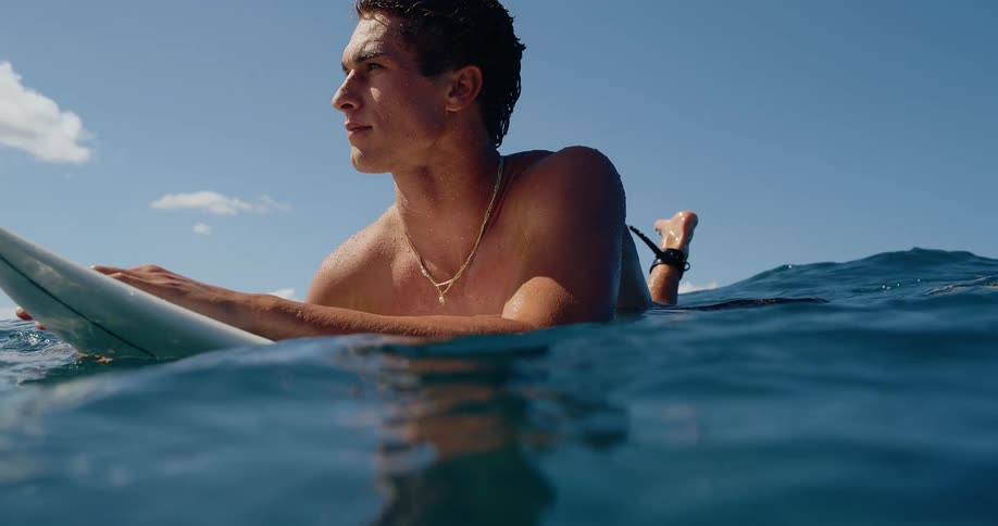 The man floats on his surfboard in the ocean