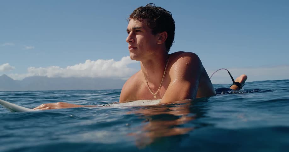 Man lying on a surfboard in the ocean