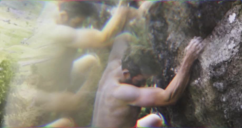 Shirtless climber ascends a steep rock