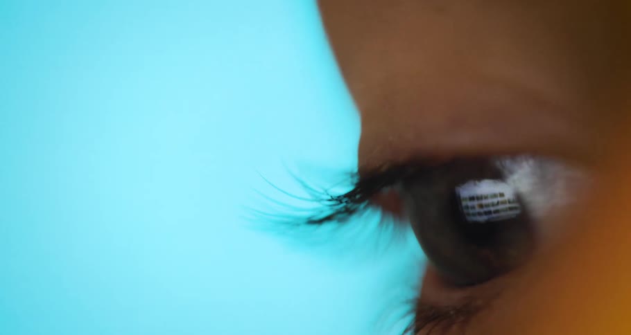 A persons eye blinks while looking to the side