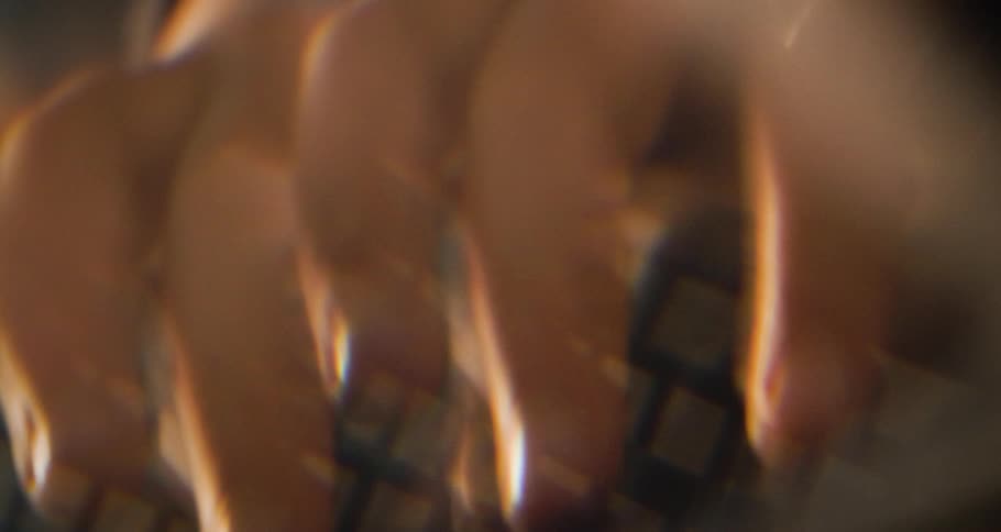 Fingers typing quickly on a computer keyboard