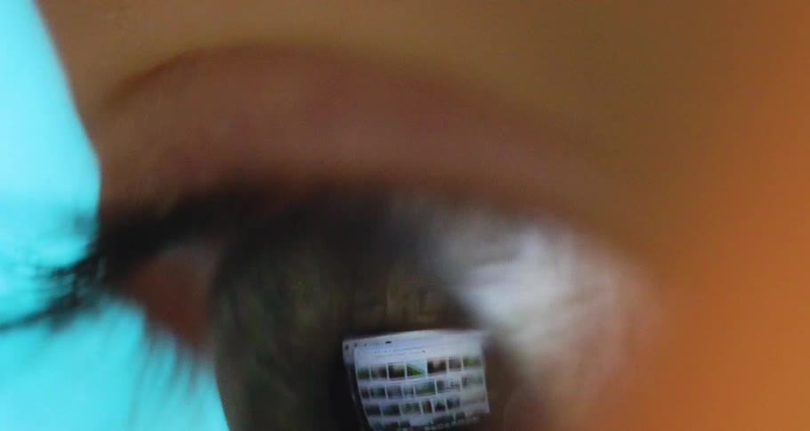 Extreme closeup of a persons eye with a reflection from a screen