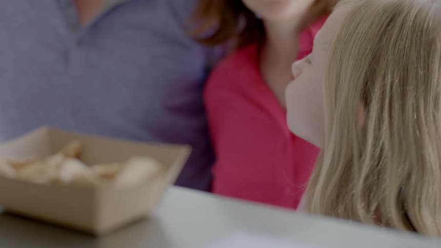 A girl tastes a sample of ice cream in an ice cream parlor