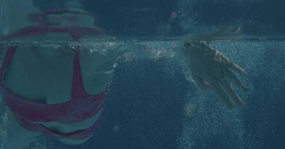 The woman is swimming in the pool
