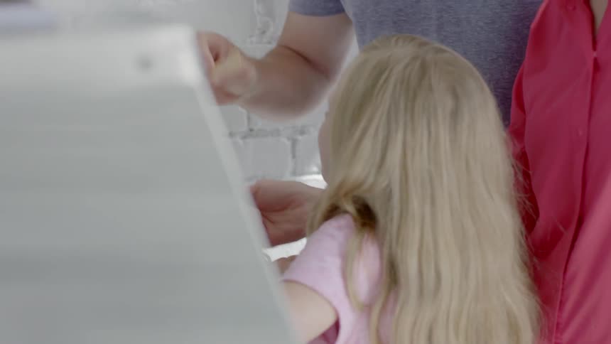 Man tasting something and giving it a thumbs up to a woman and child that are there with him